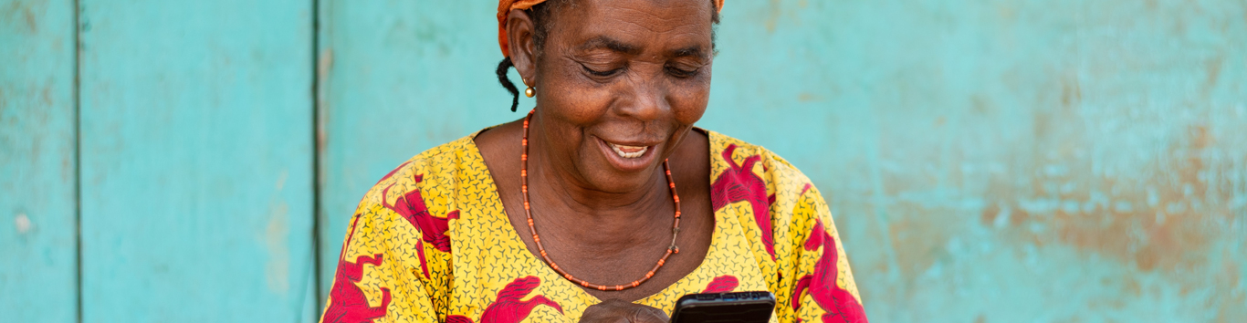 Smiling elderly african woman using her smartphone